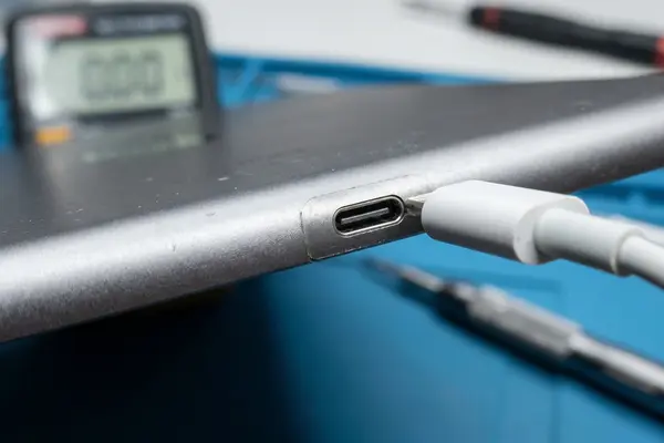 Tecnico PR Riparazioni Bologna mentre sostituisce il connettore ricarica di un iPad Pro su banco da lavoro professionale
